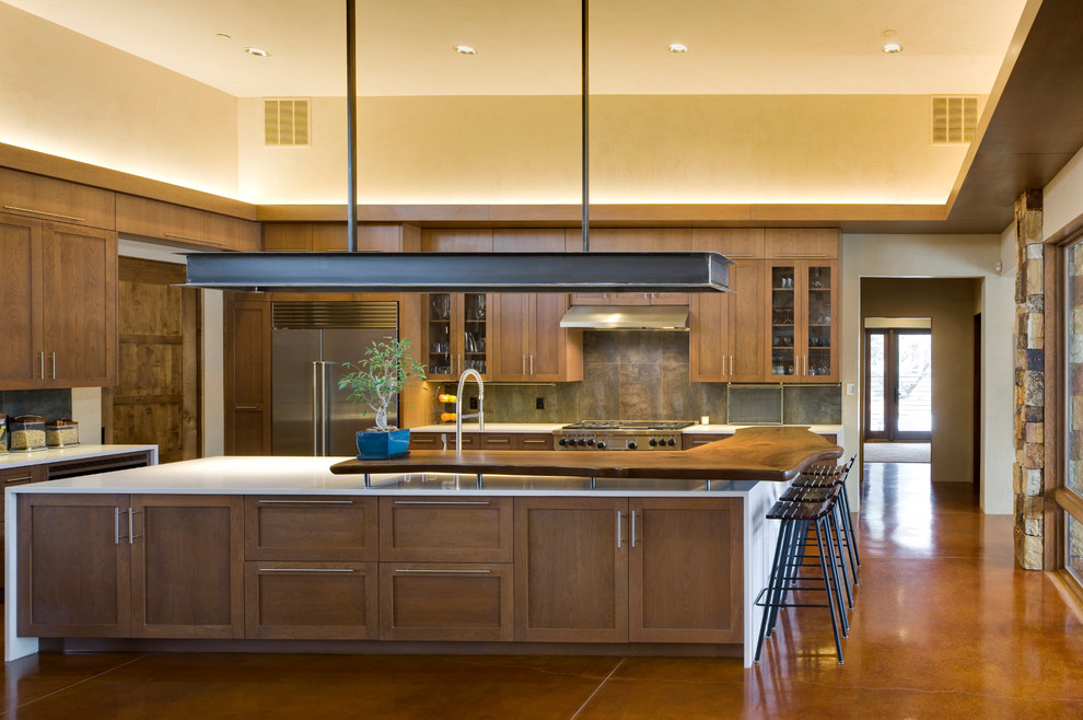Geräumige Moderne Wohnküche in U-Form mit Schrankfronten im Shaker-Stil, dunklen Holzschränken, Küchengeräten aus Edelstahl, Betonboden und Kücheninsel in Albuquerque
