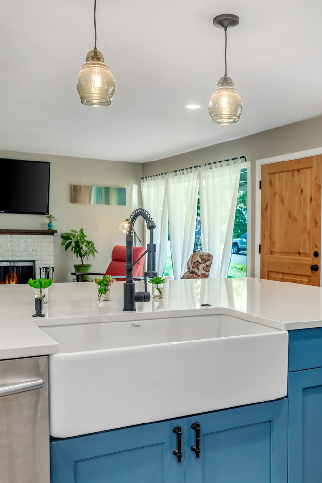 Large transitional l-shaped dark wood floor and brown floor kitchen photo in Portland with a farmhouse sink, recessed-panel cabinets, blue cabinets, quartz countertops, white backsplash, subway tile backsplash, stainless steel appliances, an island and white countertops