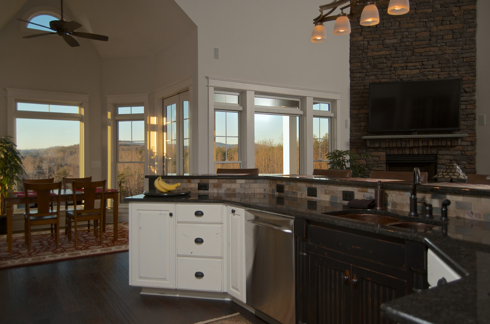 Example of a large arts and crafts dark wood floor eat-in kitchen design in Charlotte with a double-bowl sink, raised-panel cabinets, distressed cabinets, granite countertops, brown backsplash, ceramic backsplash, stainless steel appliances and an island