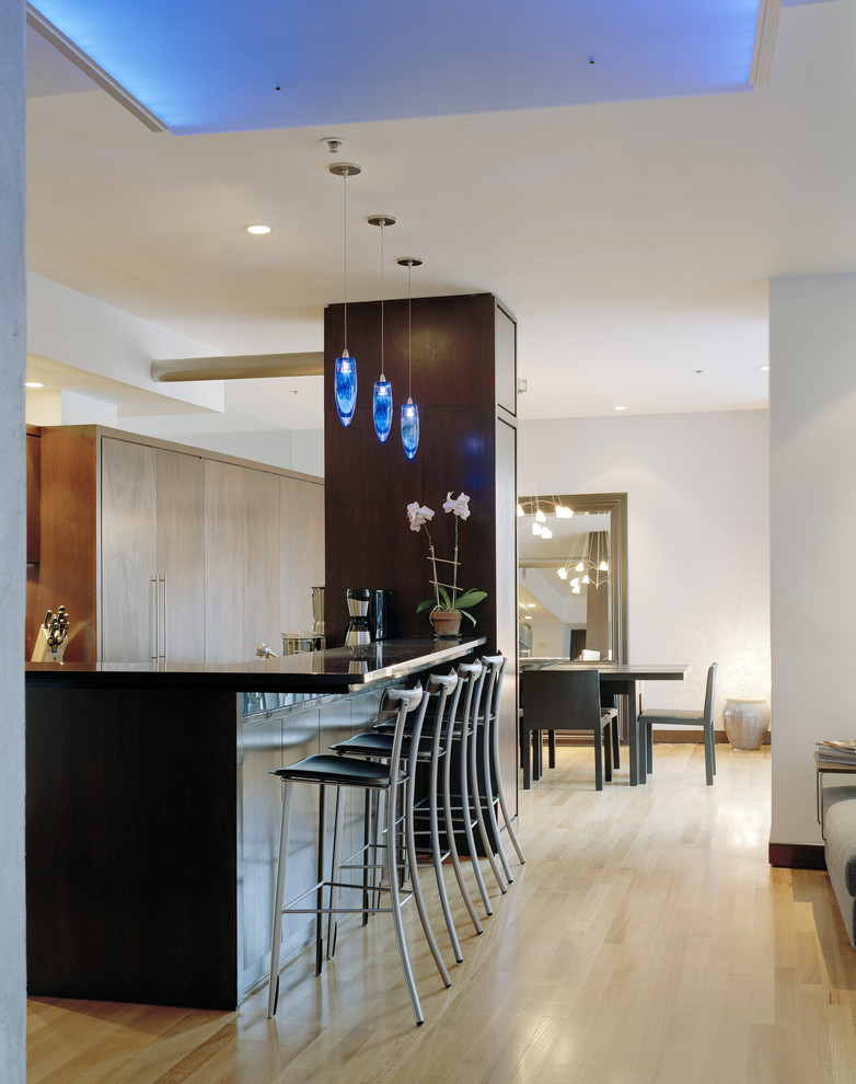 Стильный дизайн: кухня в современном стиле с обеденным столом, плоскими фасадами и светлыми деревянными фасадами - последний тренд