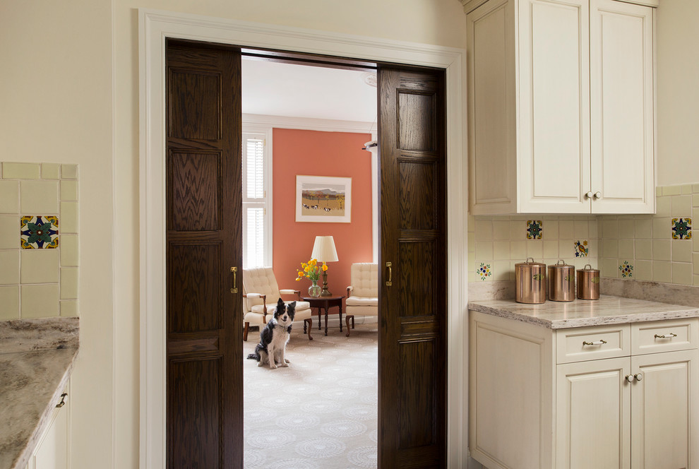 Inspiration for a large timeless l-shaped medium tone wood floor kitchen remodel in Boston with raised-panel cabinets, white cabinets, an undermount sink, quartzite countertops, beige backsplash, ceramic backsplash, stainless steel appliances and an island