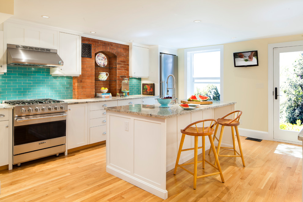 Classic galley kitchen in Boston with shaker cabinets, white cabinets, stainless steel appliances and light hardwood flooring.