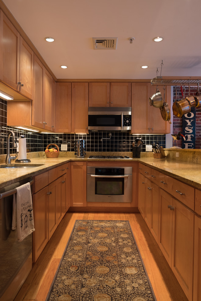 Mid-sized trendy u-shaped light wood floor and beige floor open concept kitchen photo in Boston with an undermount sink, shaker cabinets, light wood cabinets, granite countertops, black backsplash, ceramic backsplash, stainless steel appliances and a peninsula