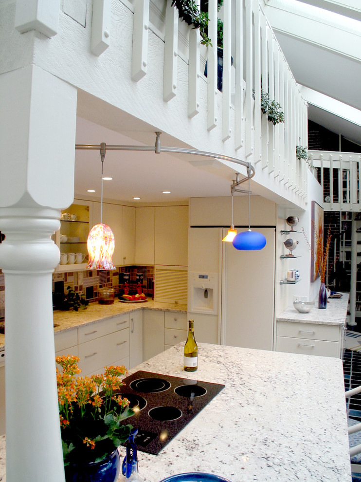 Example of a mid-sized trendy l-shaped ceramic tile eat-in kitchen design in Boston with an undermount sink, flat-panel cabinets, white cabinets, quartz countertops, multicolored backsplash, white appliances and an island