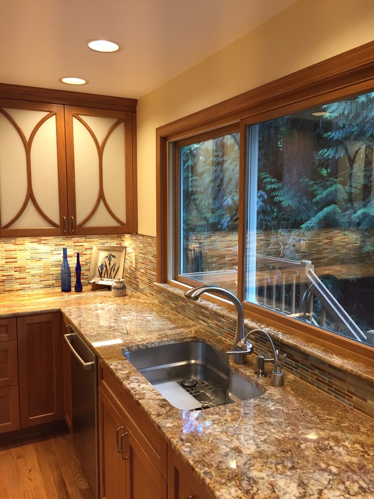 Mid-sized eclectic u-shaped medium tone wood floor and brown floor eat-in kitchen photo in Seattle with an undermount sink, shaker cabinets, medium tone wood cabinets, granite countertops, multicolored backsplash, stainless steel appliances, an island and mosaic tile backsplash