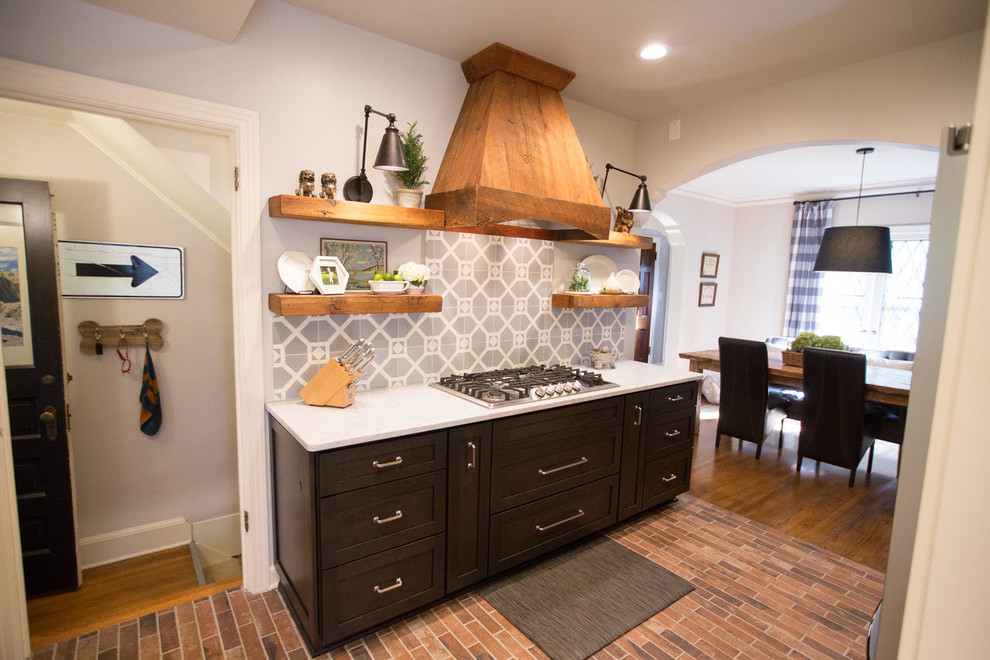 Bild på ett mellanstort vintage linjärt kök och matrum, med skåp i shakerstil, skåp i mörkt trä, bänkskiva i kvartsit, grått stänkskydd, stänkskydd i cementkakel, rostfria vitvaror och brunt golv