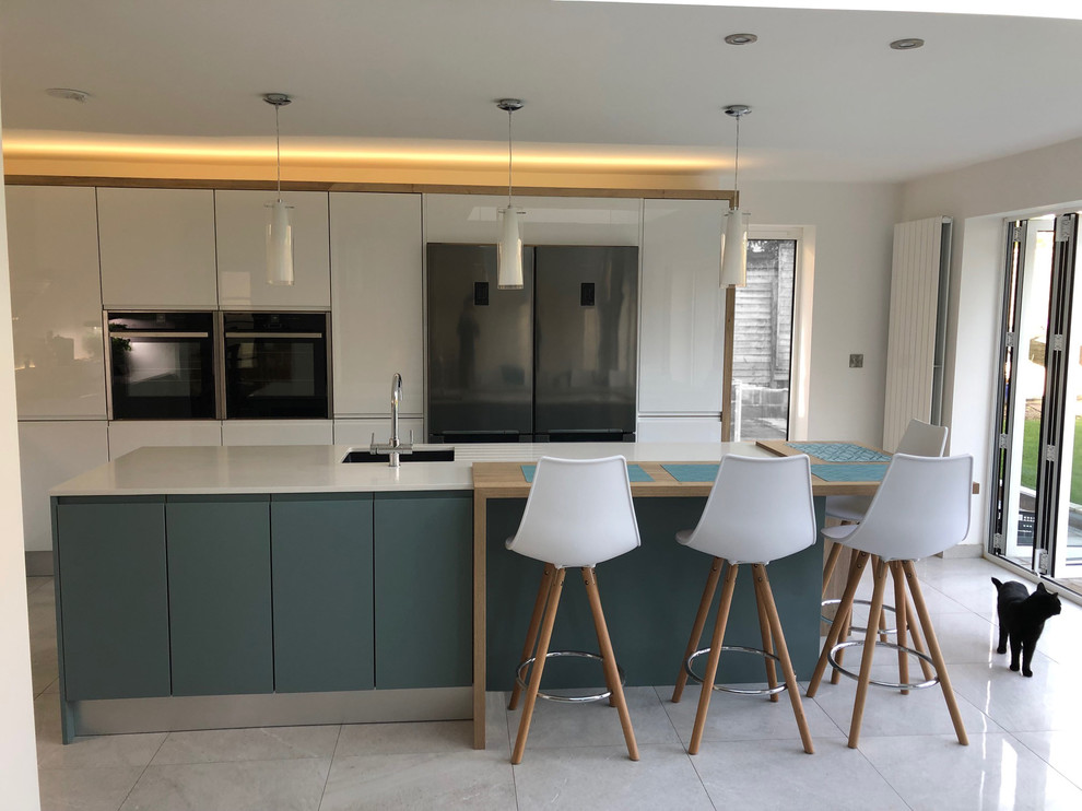 Inspiration for a medium sized modern galley kitchen/diner in Dorset with flat-panel cabinets, white cabinets, quartz worktops, an island and white worktops.