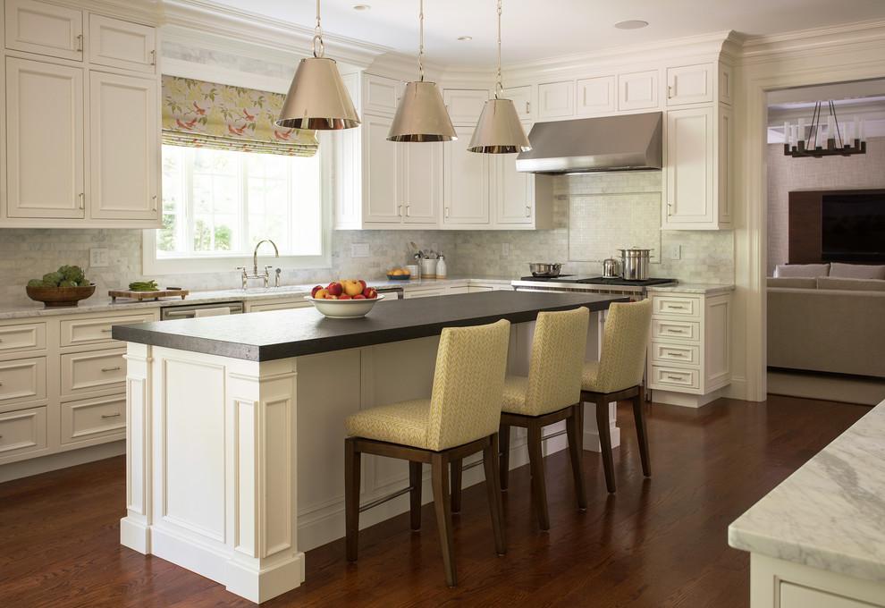 Große Klassische Küche in L-Form mit Kassettenfronten, weißen Schränken, Küchenrückwand in Grau, Küchengeräten aus Edelstahl, braunem Holzboden, Kücheninsel und Arbeitsplatte aus Holz in Boston
