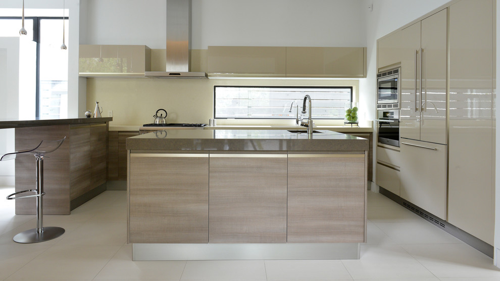 This is an example of a large modern u-shaped kitchen/diner in Houston with a built-in sink, flat-panel cabinets, beige cabinets, granite worktops, beige splashback, stainless steel appliances, ceramic flooring and an island.