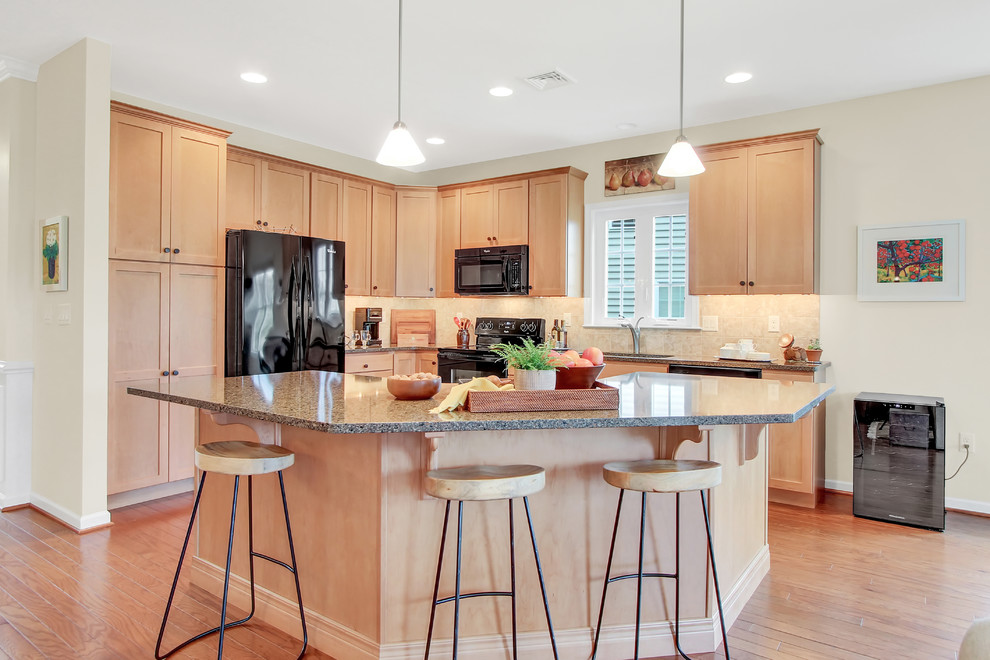 Elegant l-shaped medium tone wood floor and brown floor kitchen photo in Other with an undermount sink, shaker cabinets, light wood cabinets, beige backsplash, black appliances, an island and gray countertops