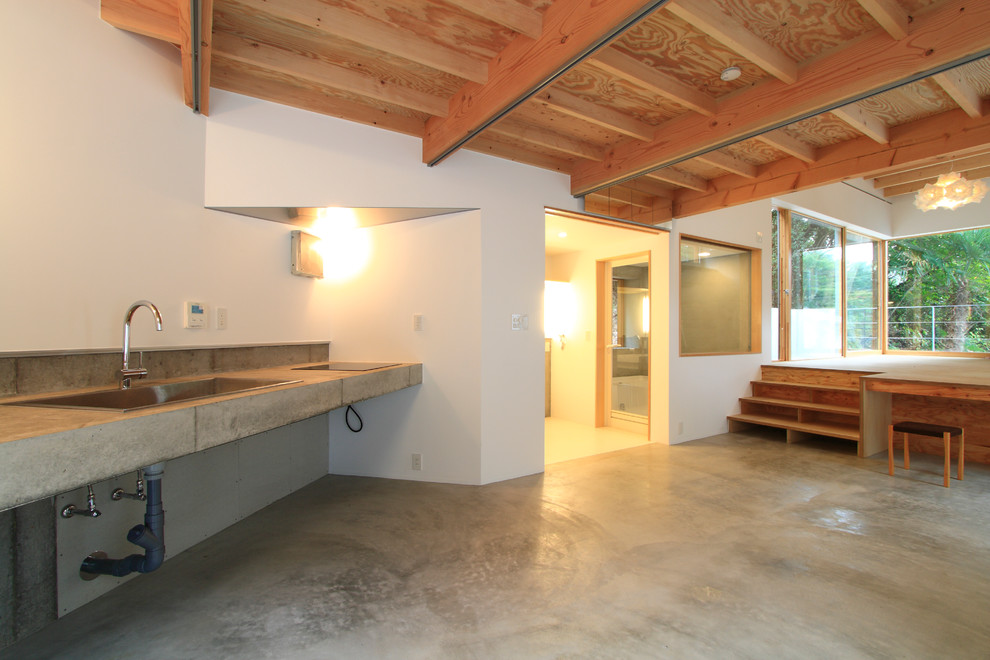 Idéer för att renovera ett litet funkis linjärt kök med öppen planlösning, med en nedsänkt diskho, öppna hyllor, bänkskiva i betong, grått stänkskydd, stänkskydd i cementkakel och betonggolv