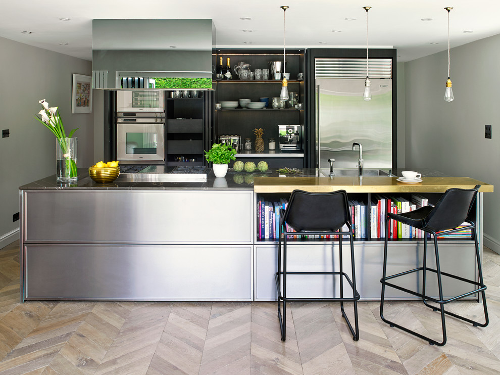 Immagine di una cucina minimal di medie dimensioni con lavello sottopiano, ante lisce, ante nere, elettrodomestici in acciaio inossidabile, pavimento in legno massello medio, penisola e pavimento marrone