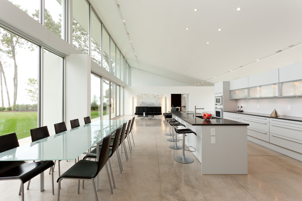 Immagine di una cucina design con ante lisce, ante bianche e pavimento grigio