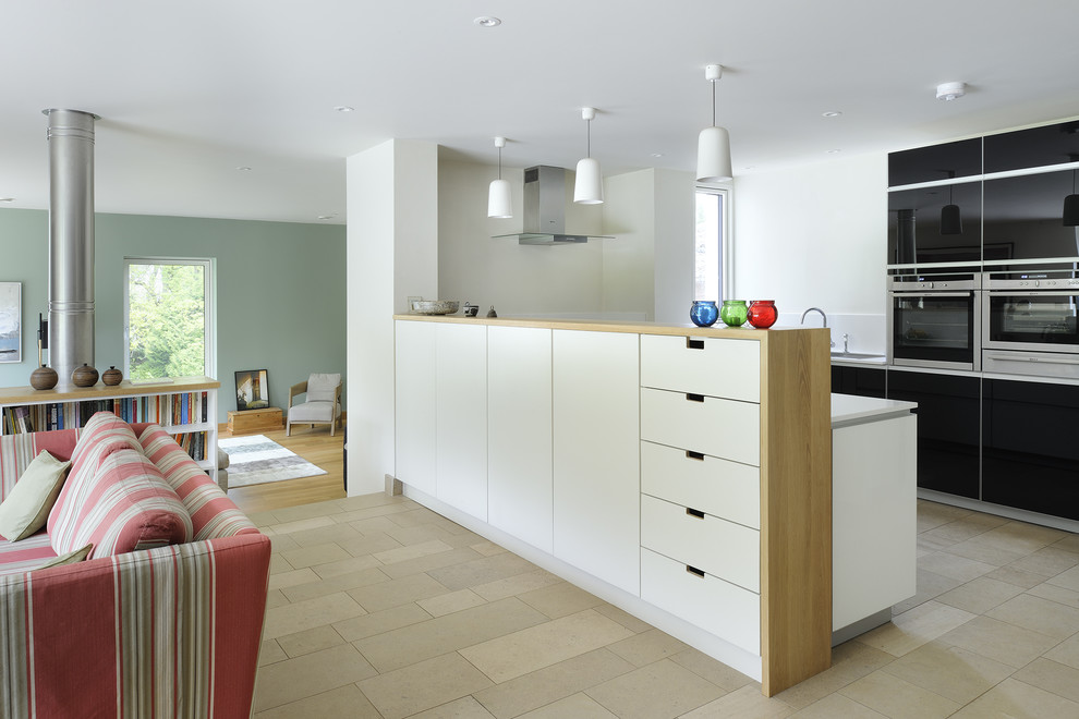 Contemporary u-shaped open plan kitchen in Hampshire with flat-panel cabinets, black cabinets, stainless steel appliances and a breakfast bar.