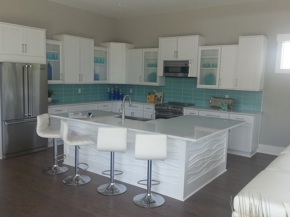 Design ideas for a large nautical l-shaped kitchen/diner in Tampa with a belfast sink, shaker cabinets, white cabinets, quartz worktops, green splashback, glass tiled splashback, stainless steel appliances, medium hardwood flooring and an island.