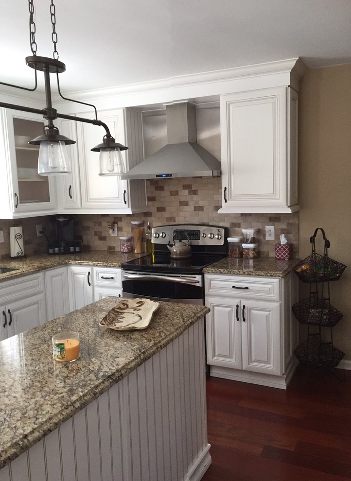 Foto på ett mellanstort vintage kök, med en dubbel diskho, luckor med upphöjd panel, vita skåp, granitbänkskiva, brunt stänkskydd, stänkskydd i tunnelbanekakel, rostfria vitvaror, mörkt trägolv och en köksö