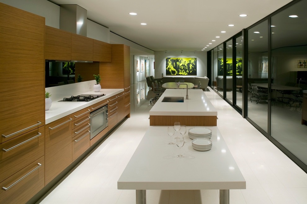 Photo of a modern galley open plan kitchen in Phoenix with a submerged sink, flat-panel cabinets, medium wood cabinets and integrated appliances.