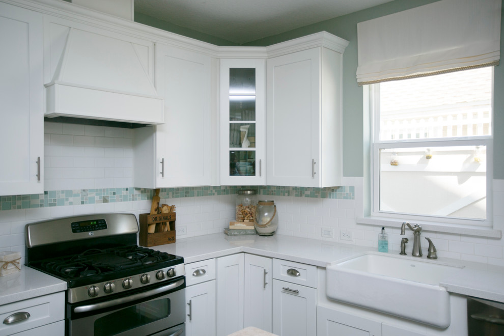 Exempel på ett litet maritimt kök, med en undermonterad diskho, skåp i shakerstil, vita skåp, granitbänkskiva, vitt stänkskydd, stänkskydd i tunnelbanekakel, rostfria vitvaror, mörkt trägolv, en köksö och brunt golv