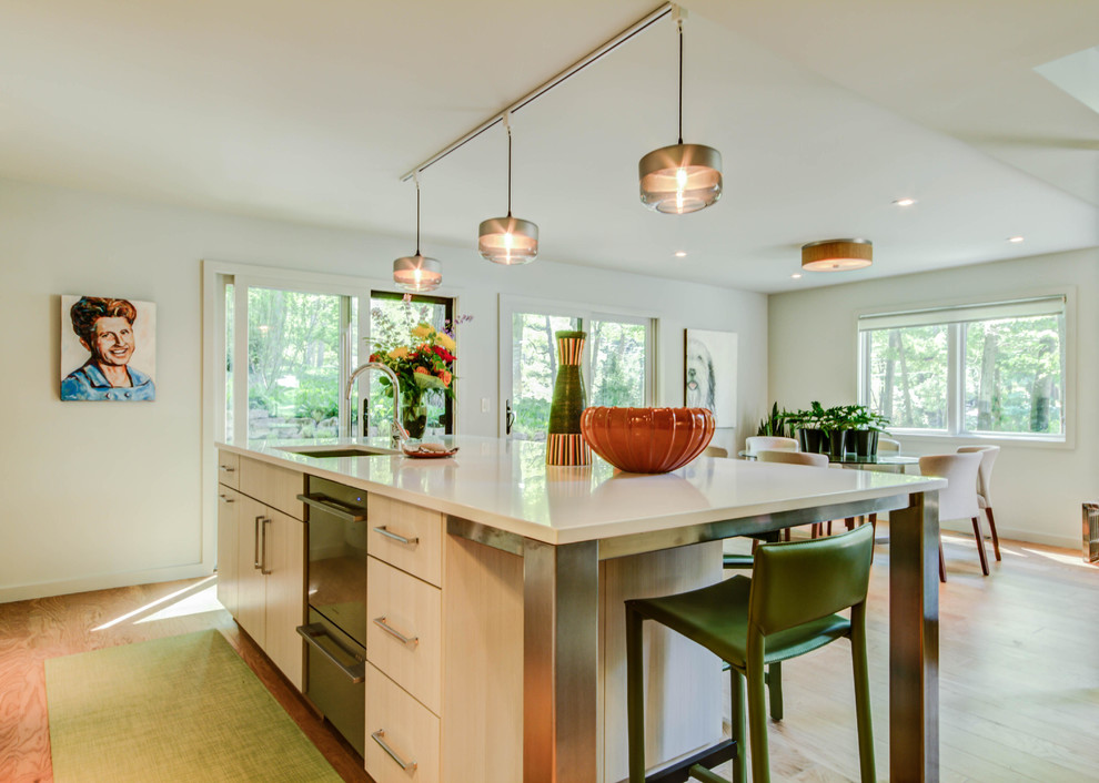 Mid-sized mid-century modern galley eat-in kitchen photo in Grand Rapids with an undermount sink, flat-panel cabinets, light wood cabinets, quartz countertops, white backsplash, ceramic backsplash, stainless steel appliances and an island