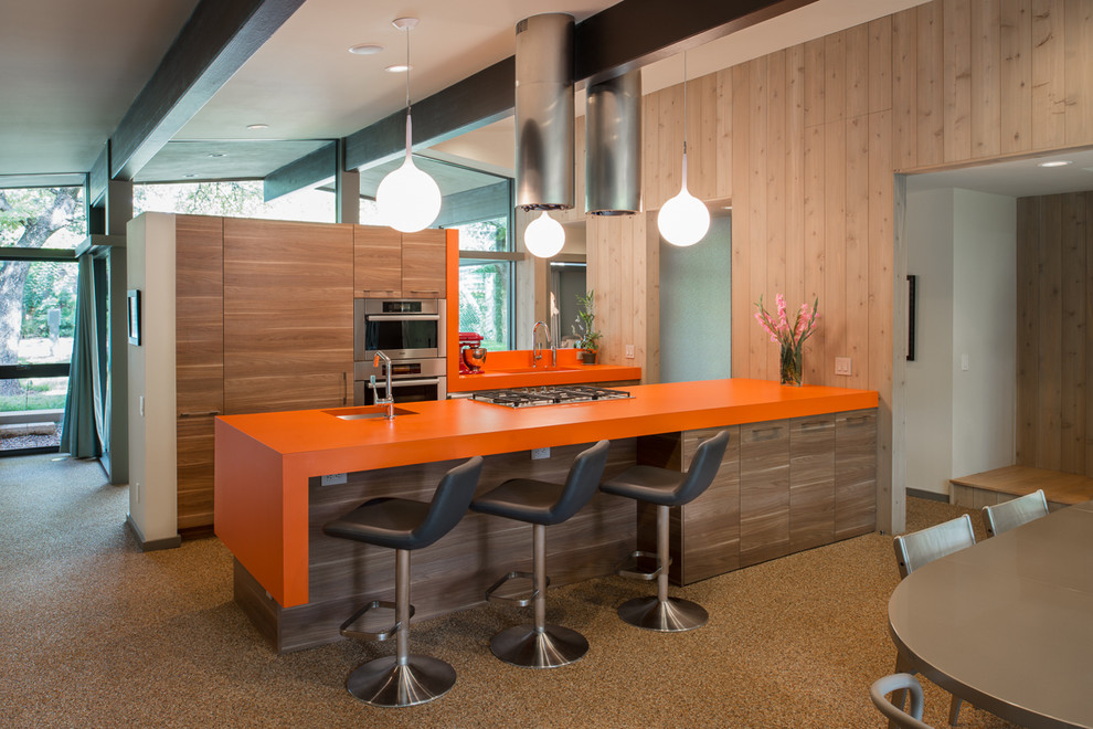 Идея дизайна: параллельная кухня в стиле ретро с обеденным столом, врезной мойкой, плоскими фасадами, фасадами цвета дерева среднего тона, техникой из нержавеющей стали, оранжевой столешницей и окном