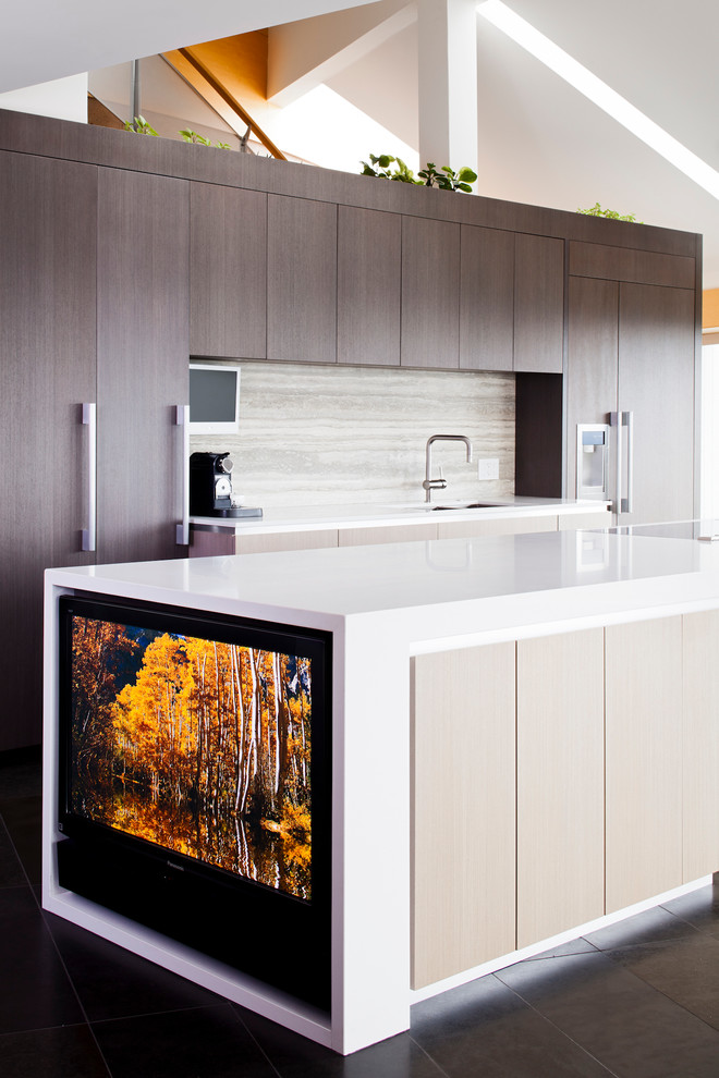 Large contemporary single-wall open plan kitchen in Vancouver with flat-panel cabinets, medium wood cabinets, engineered stone countertops, slate flooring, an island, a submerged sink, grey splashback, stone slab splashback and integrated appliances.