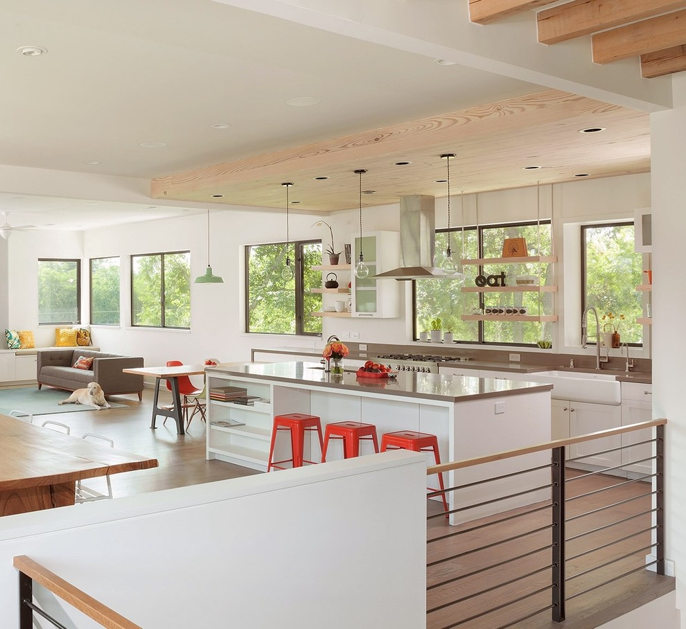 Trendy single-wall open concept kitchen photo in Houston with a farmhouse sink, shaker cabinets, white cabinets, stainless steel appliances, quartz countertops, beige backsplash and stone slab backsplash
