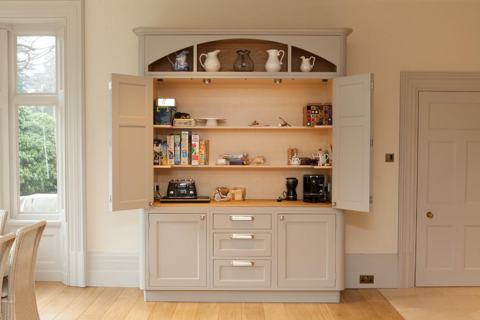 Aménagement d'une cuisine classique avec un placard avec porte à panneau encastré et des portes de placard beiges.