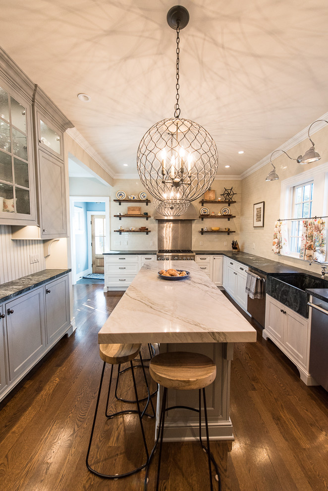 Inspiration for a small cottage u-shaped medium tone wood floor enclosed kitchen remodel in New York with an integrated sink, beaded inset cabinets, white cabinets, quartzite countertops, white backsplash, ceramic backsplash, stainless steel appliances and an island