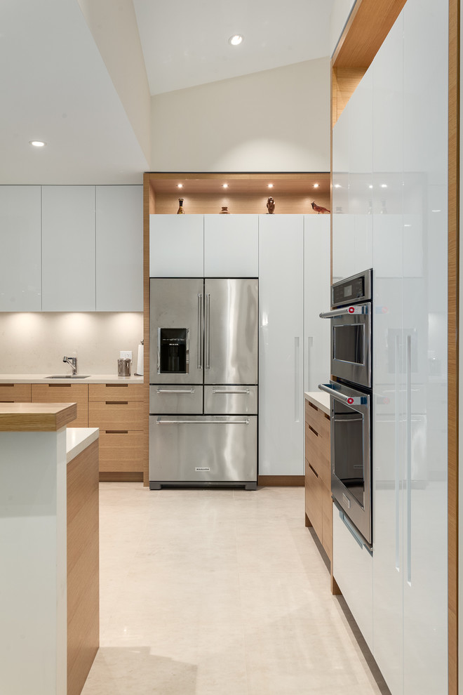 Large minimalist u-shaped limestone floor open concept kitchen photo in Vancouver with flat-panel cabinets, light wood cabinets, granite countertops, beige backsplash, stainless steel appliances, a peninsula and an undermount sink