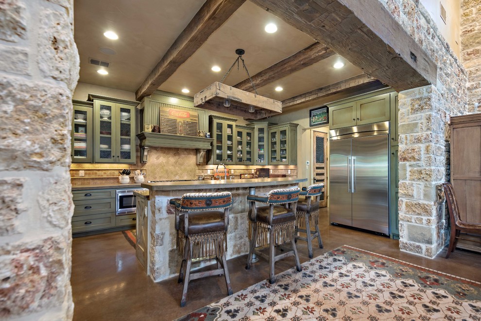 オースティンにあるラスティックスタイルのおしゃれなキッチン (シェーカースタイル扉のキャビネット、緑のキャビネット、ベージュキッチンパネル、シルバーの調理設備、茶色い床) の写真