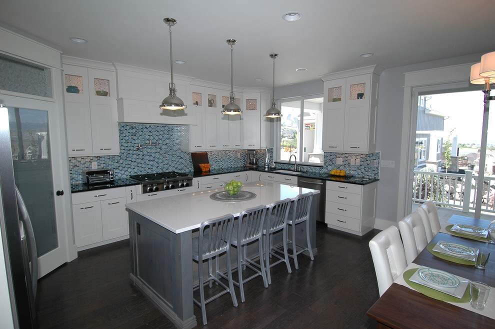 Example of a large trendy l-shaped dark wood floor and brown floor eat-in kitchen design in Salt Lake City with an undermount sink, shaker cabinets, white cabinets, quartz countertops, multicolored backsplash, mosaic tile backsplash, stainless steel appliances and an island