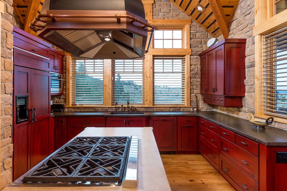 Exempel på ett mellanstort rustikt u-kök, med en dubbel diskho, skåp i shakerstil, röda skåp, bänkskiva i koppar, brunt stänkskydd, stänkskydd i stenkakel, integrerade vitvaror, mellanmörkt trägolv och en köksö