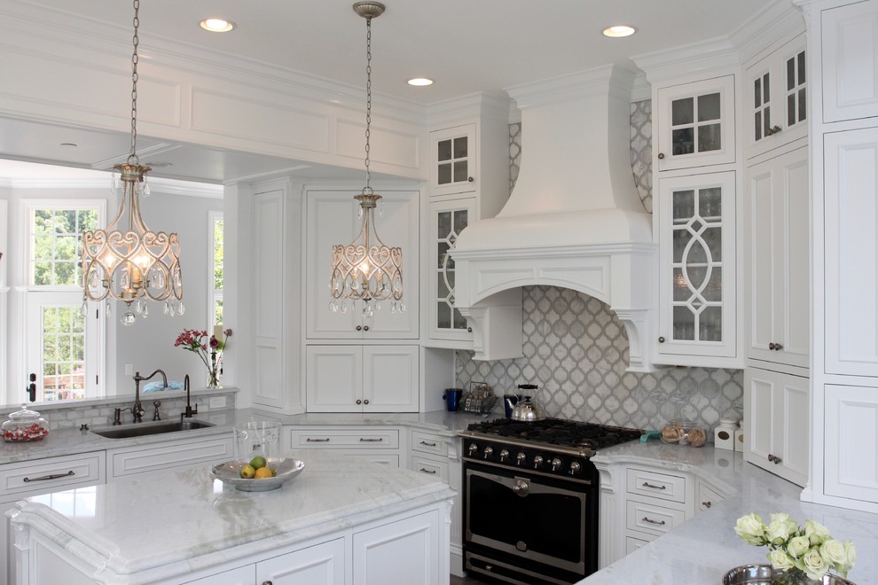 Inspiration for a mid-sized timeless u-shaped medium tone wood floor kitchen remodel in DC Metro with an undermount sink, recessed-panel cabinets, white cabinets, quartzite countertops, gray backsplash, stone tile backsplash, paneled appliances and an island