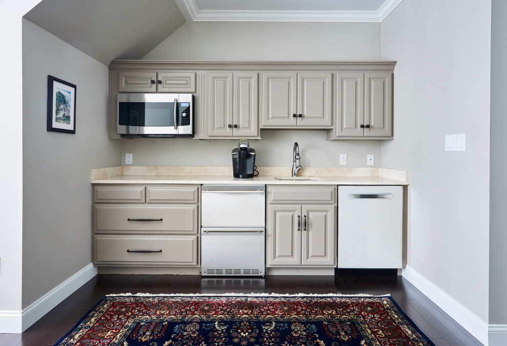 Cette image montre une petite cuisine américaine linéaire design avec un évier posé, un placard avec porte à panneau encastré, des portes de placard beiges, un plan de travail en granite, un électroménager de couleur et parquet foncé.