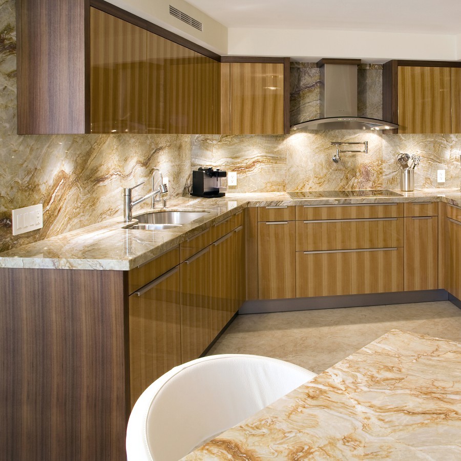 Mid-sized trendy u-shaped travertine floor and beige floor enclosed kitchen photo in Miami with an undermount sink, flat-panel cabinets, beige cabinets, quartzite countertops, beige backsplash, stone slab backsplash and a peninsula