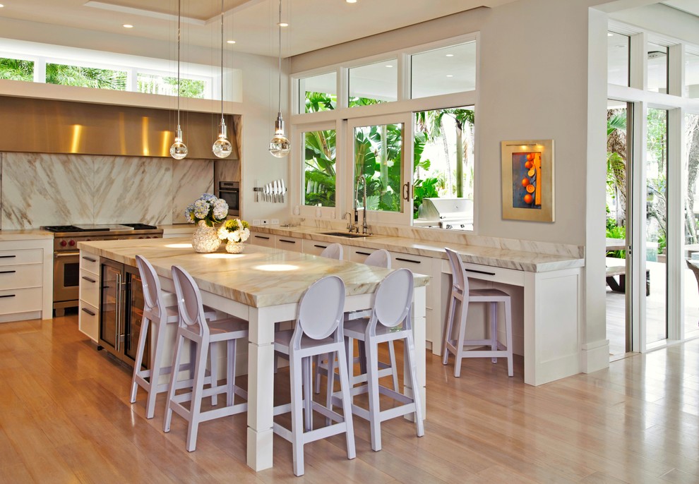 Immagine di un cucina con isola centrale chic con lavello sottopiano, ante beige e elettrodomestici in acciaio inossidabile