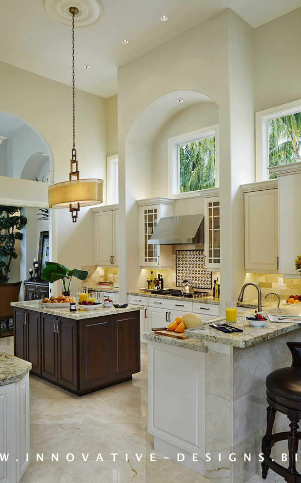Example of a mid-sized trendy u-shaped travertine floor open concept kitchen design in Miami with an undermount sink, raised-panel cabinets, light wood cabinets, granite countertops, beige backsplash, stone tile backsplash, stainless steel appliances and an island