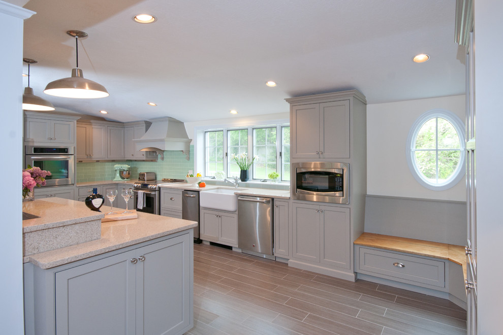 Example of a large classic u-shaped porcelain tile eat-in kitchen design in Boston with a farmhouse sink, beaded inset cabinets, gray cabinets, quartz countertops, green backsplash, glass tile backsplash, stainless steel appliances and an island