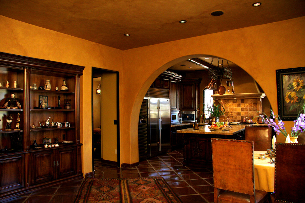 Large tuscan eat-in kitchen photo in Sacramento with recessed-panel cabinets, dark wood cabinets and an island