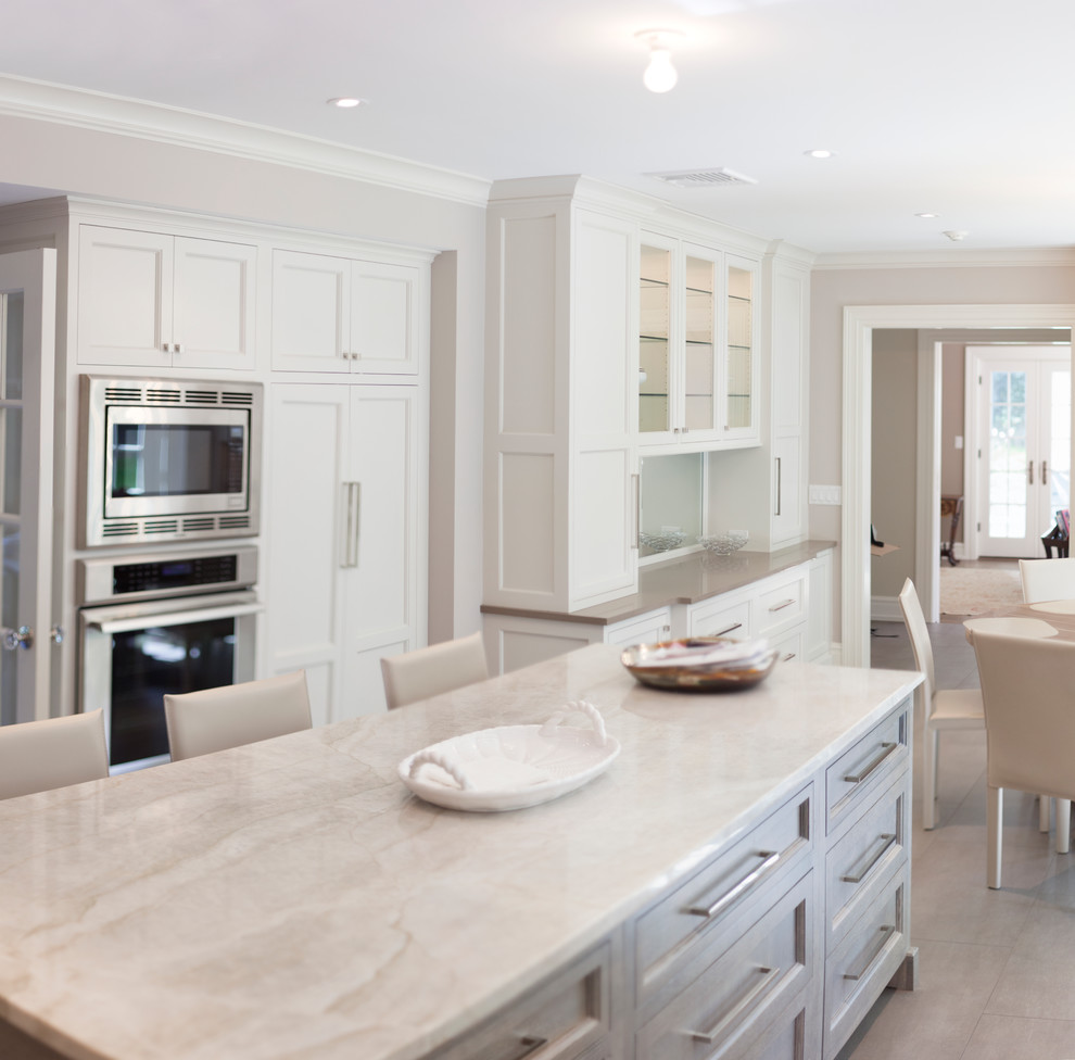 Foto de cocina clásica renovada con puertas de armario blancas, salpicadero verde y electrodomésticos de acero inoxidable