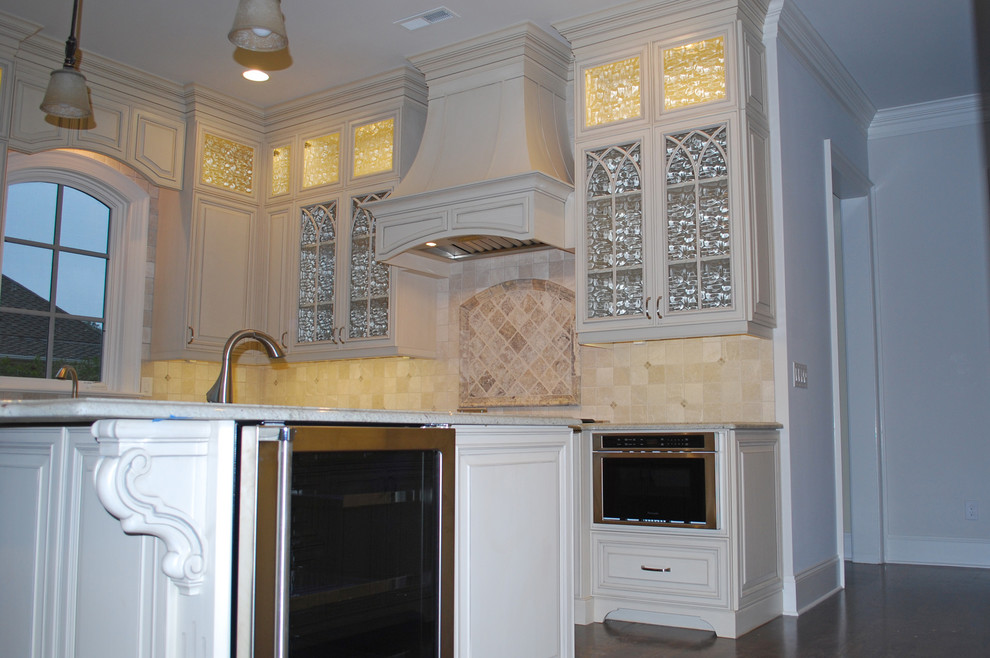 Exempel på ett mellanstort klassiskt kök, med en undermonterad diskho, luckor med upphöjd panel, vita skåp, vitt stänkskydd, rostfria vitvaror, mörkt trägolv och en köksö