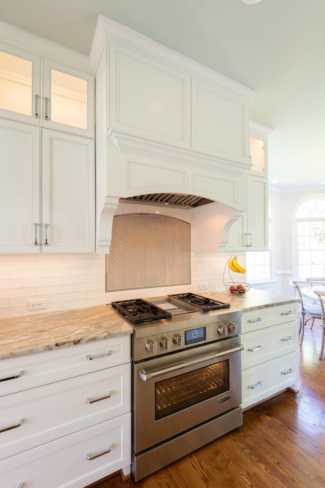 Foto på ett stort vintage beige kök och matrum, med en undermonterad diskho, vita skåp, granitbänkskiva, flerfärgad stänkskydd, stänkskydd i keramik, rostfria vitvaror, mellanmörkt trägolv, en köksö och brunt golv
