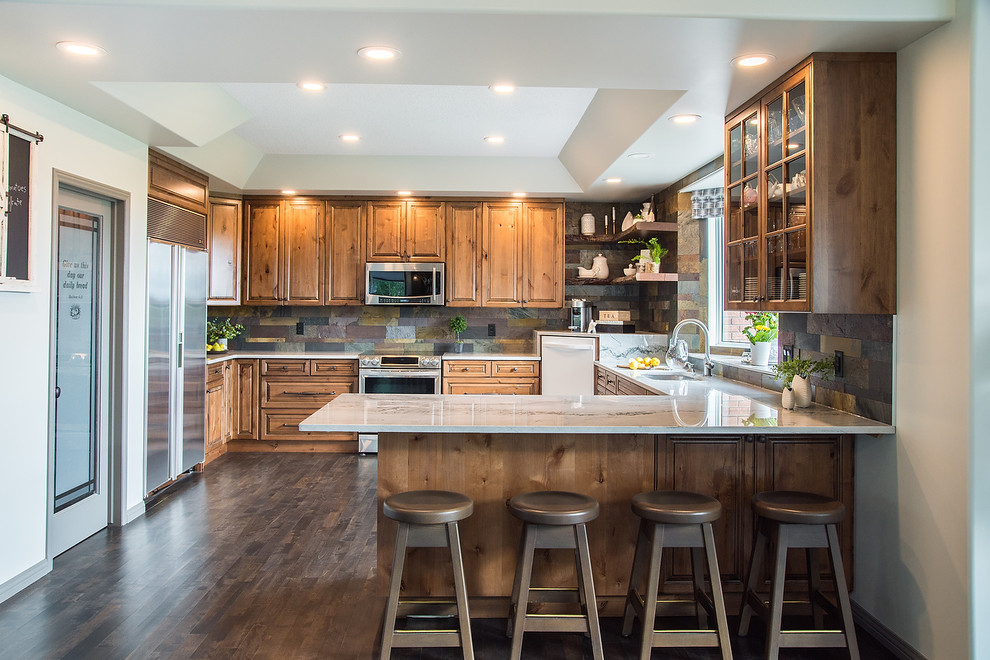 Bild på ett stort rustikt flerfärgad flerfärgat kök, med en dubbel diskho, luckor med upphöjd panel, skåp i slitet trä, bänkskiva i kvartsit, flerfärgad stänkskydd, stänkskydd i skiffer, rostfria vitvaror, mellanmörkt trägolv och grått golv