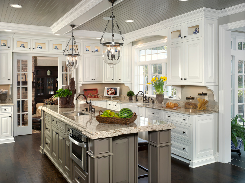 Exempel på ett stort klassiskt kök, med en rustik diskho, luckor med upphöjd panel, vita skåp, granitbänkskiva, beige stänkskydd, mörkt trägolv och en köksö