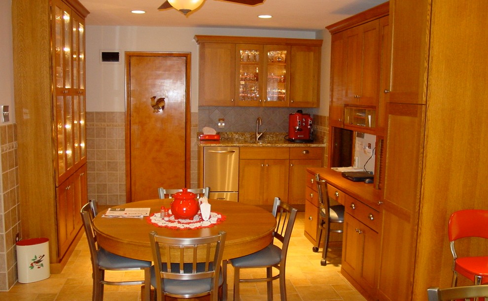 На фото: п-образная кухня в классическом стиле с обеденным столом, врезной мойкой, фасадами в стиле шейкер, светлыми деревянными фасадами, гранитной столешницей, синим фартуком и техникой из нержавеющей стали