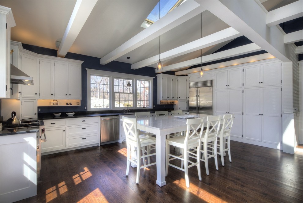 This is an example of a large traditional u-shaped kitchen/diner in Providence with recessed-panel cabinets, white cabinets, composite countertops, blue splashback, stainless steel appliances, dark hardwood flooring and an island.