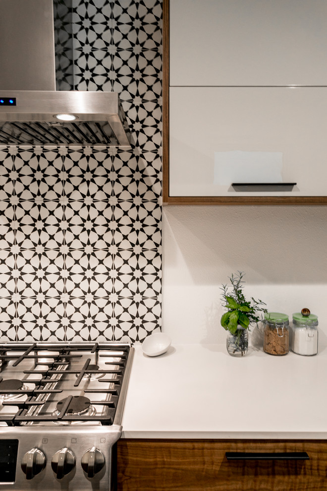 Réalisation d'une petite cuisine parallèle minimaliste avec un placard à porte plane, des portes de placard beiges, un plan de travail en quartz modifié et parquet clair.