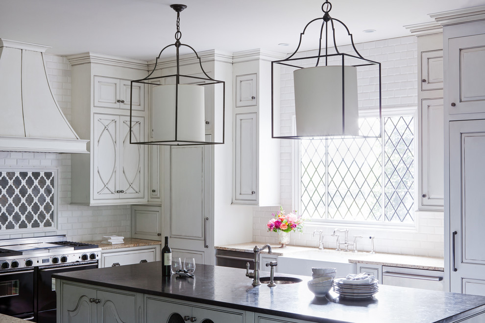 Example of a cottage kitchen design in Nashville with a farmhouse sink, beaded inset cabinets, white cabinets, white backsplash, subway tile backsplash and an island