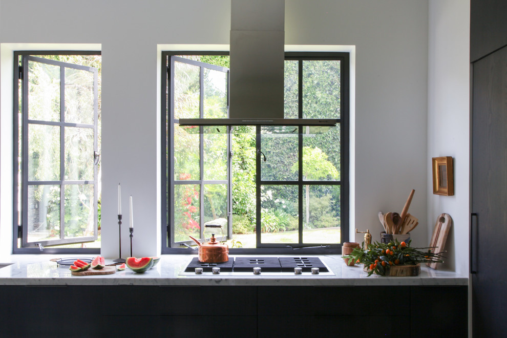 Foto di una cucina contemporanea di medie dimensioni con lavello sottopiano, ante lisce, ante nere e elettrodomestici in acciaio inossidabile