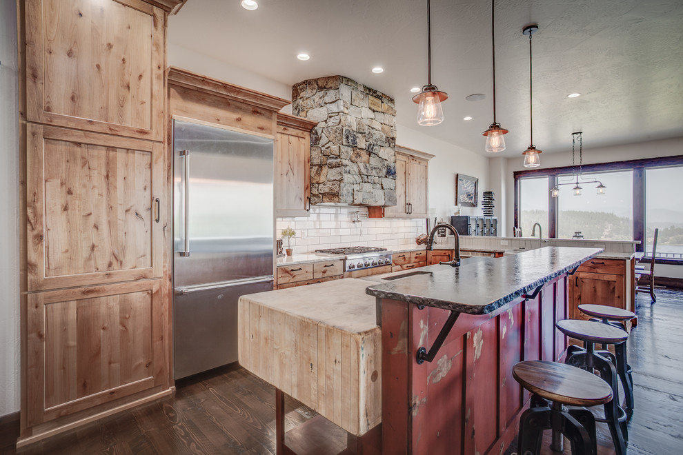 Eat-in kitchen - mid-sized rustic single-wall dark wood floor eat-in kitchen idea in Seattle with shaker cabinets, medium tone wood cabinets, granite countertops, white backsplash, subway tile backsplash, stainless steel appliances and an island